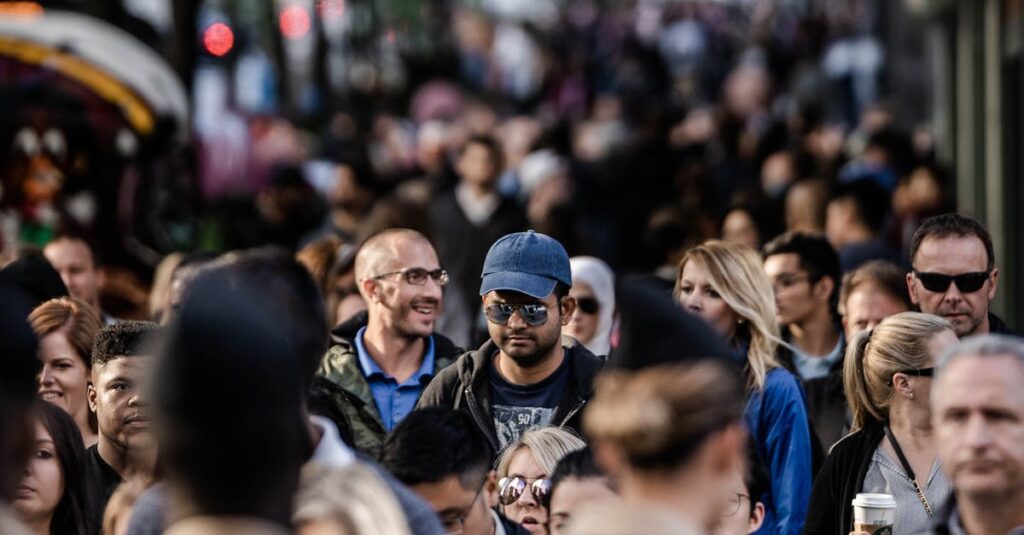 Πάνω από 1,6 Εκατομμύρια Έλληνες Έχουν Ζήσει τη Φυλάκιση Συγγενούς – Σοκαριστικά Στατιστικά και Κοινωνικές Επιπτώσεις των Φυλακών στην Ελλάδα 10 A bustling urban scene with diverse people walking on a tree-lined city street.