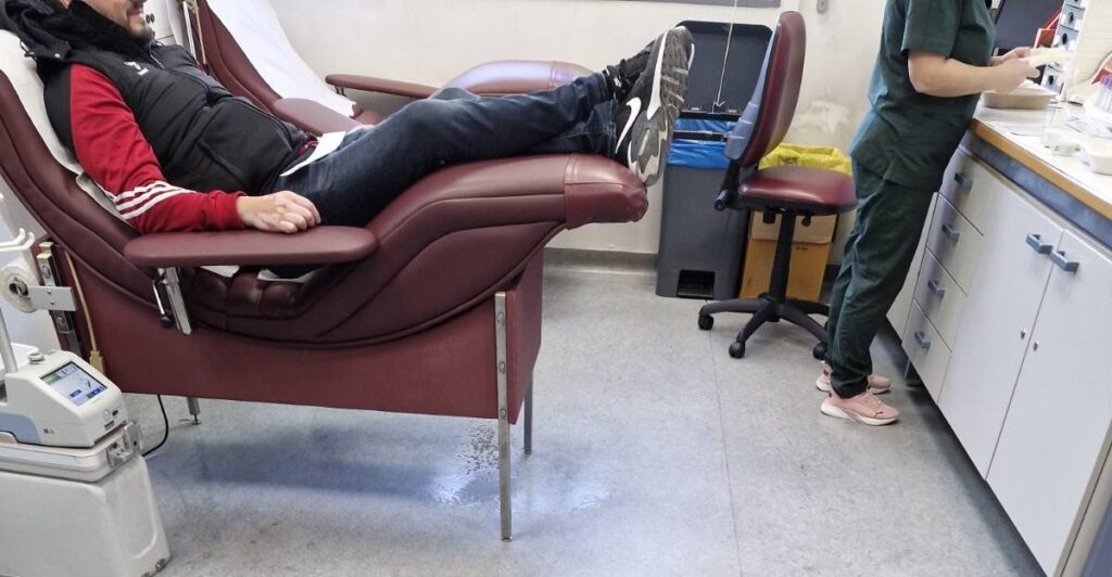 άντρας που δίνει εθελοντικά αίμα για τον σύλλογο «Στήριξη Οικογενειών Κρατουμένων – Ο Άγιος Ελευθέριος» στο Γενικό Νοσοκομείο Θεσσαλονίκης “Ιπποκράτειο”