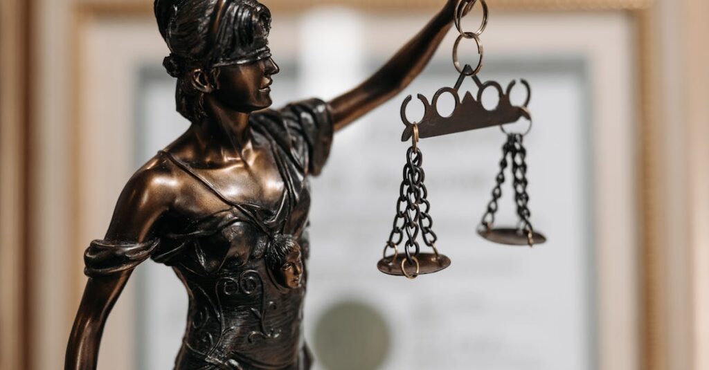 Close-up of a bronze Lady Justice statue holding scales in an office environment.