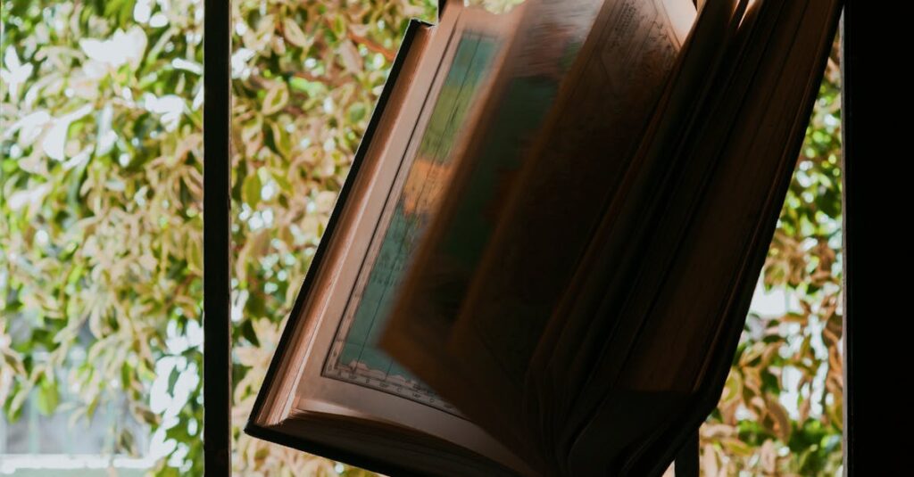 An open book rests on a windowsill with greenery in the background, capturing a peaceful moment.