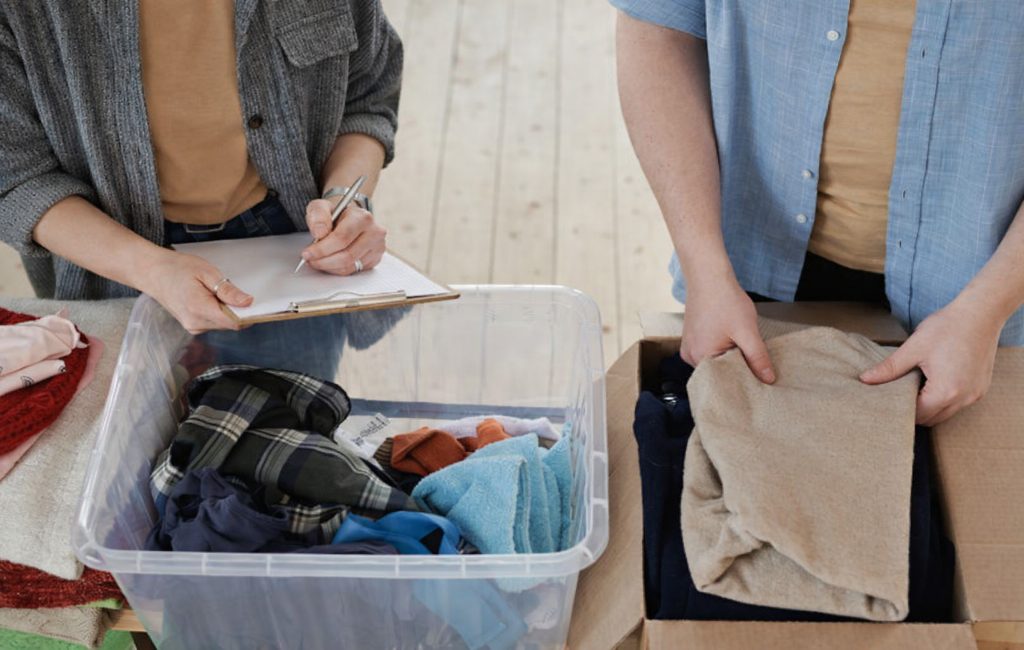 Στήριξη κρατουμένων με βασικά είδη ανάγκης 3 εθελοντές συγκεντρώνουν και ταξινομούν ρούχα για δωρεά σε κρατούμενους